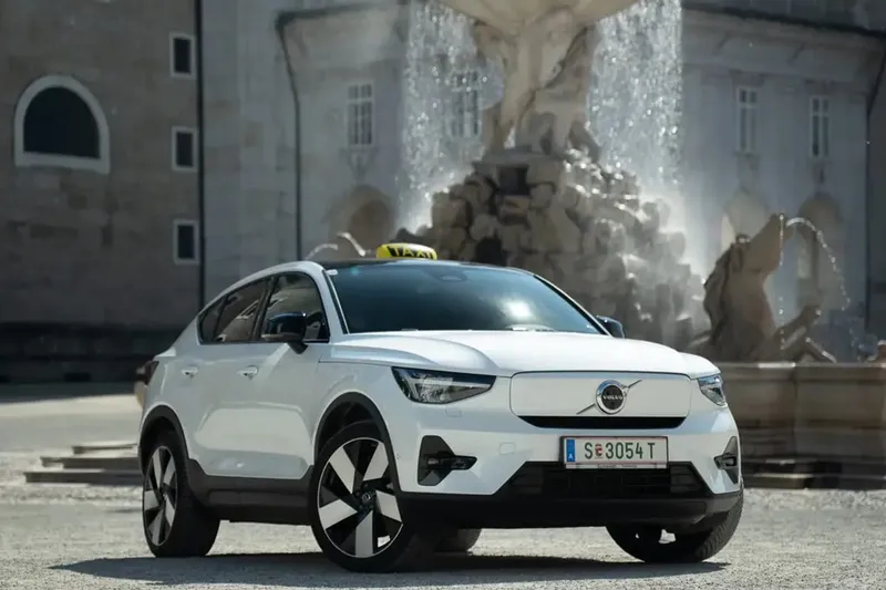 Weißer Volvo C40 Elektro-Taxi vor dem Salzburger Residenzbrunnen