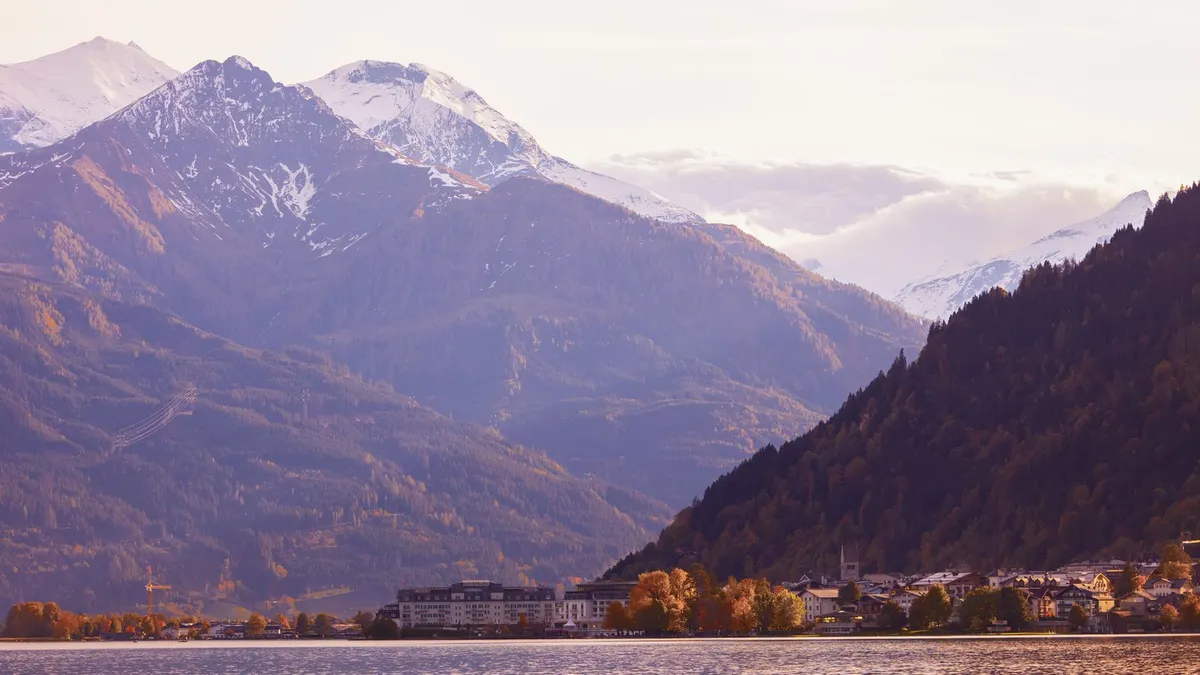 Der Zeller See mit der Uferpromenade, dahinter die Gipfel der Hohen Tauern