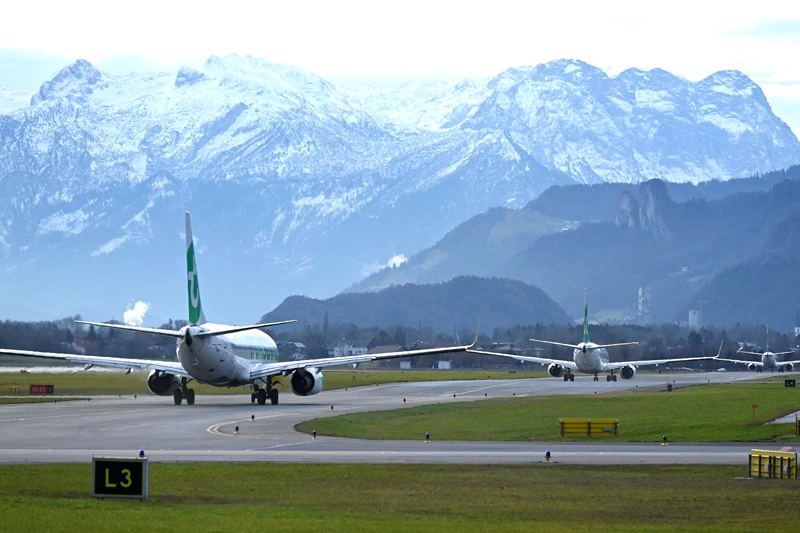 Flughafen Salzburg mit Flugzeugen und Alpen im Hintergrund – Taxi & Touren Salzburg